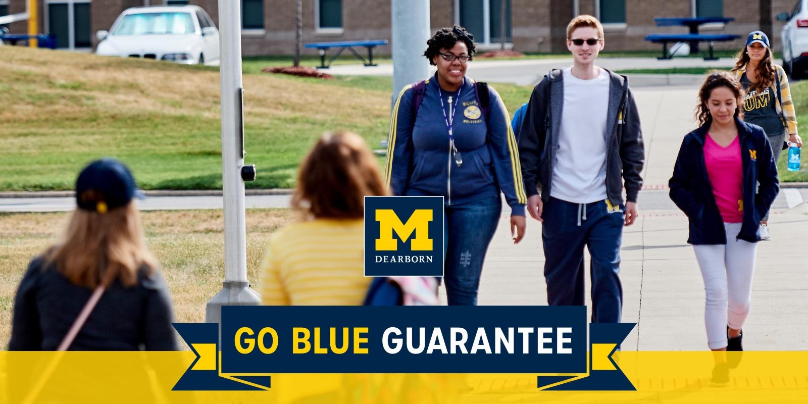 Students walking on campus wtih Go Blue Guarantee banner