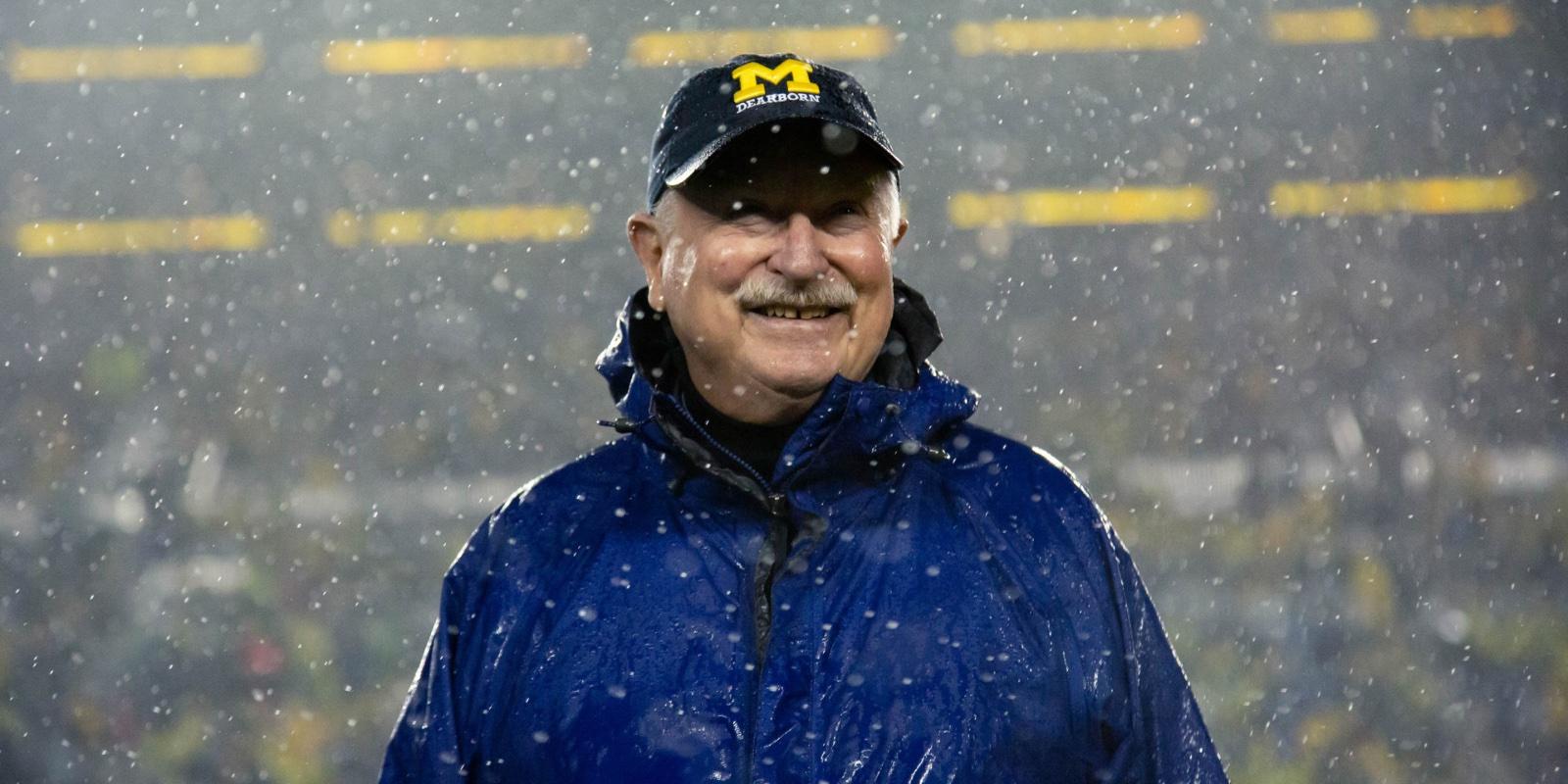 Tony England smiles while standing in the snow at Michigan Stadium