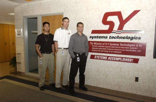 3 students standing in front of Systems Technologies