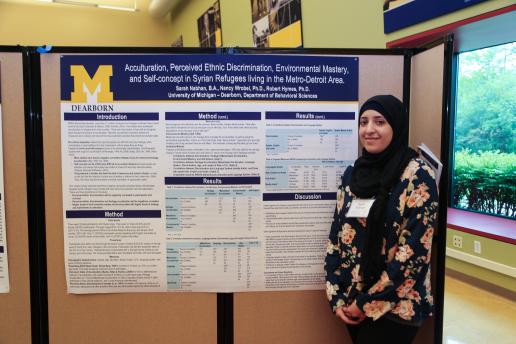 Student standing in front of her research poster.