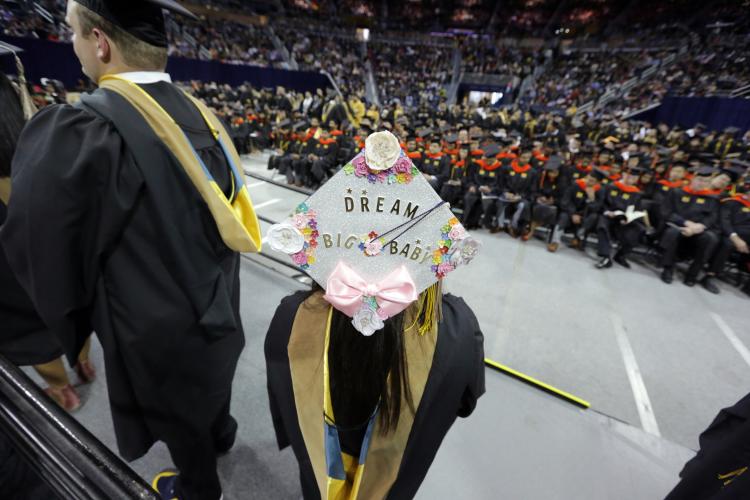 Student at Commencement with mortar board saying "Dream Big Baby"