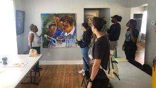 College students look at artwork on a wall in a community center in Detroit