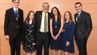 U-M President Mark Schlissel, center, congratulations recipients of the 2018 Chancellor's Medallion: Stephen Mara, Marybeth Muliett, Monica De Roche, Rachel Marple and Brock Rowberry.