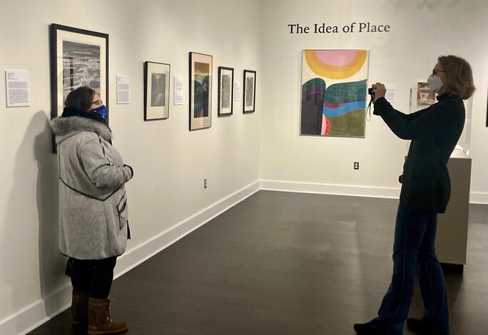 Professor Susan Erickson, right, takes a photo of student Diana Guzman at the opening of the "Picturing Places and Spaces" exhibit.