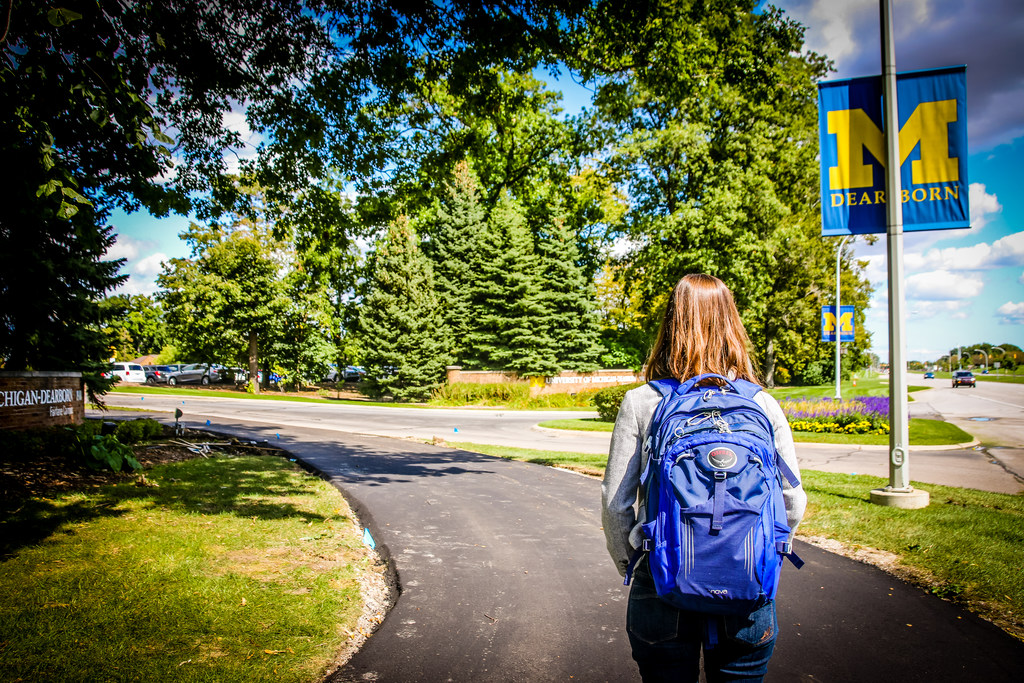 Student with blue backpack starting on path to UM-Dearborn