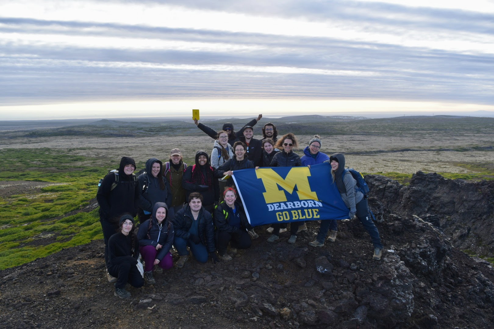 Photo of students holding a UM-Dearborn flag during the 2022 study abroad to Iceland