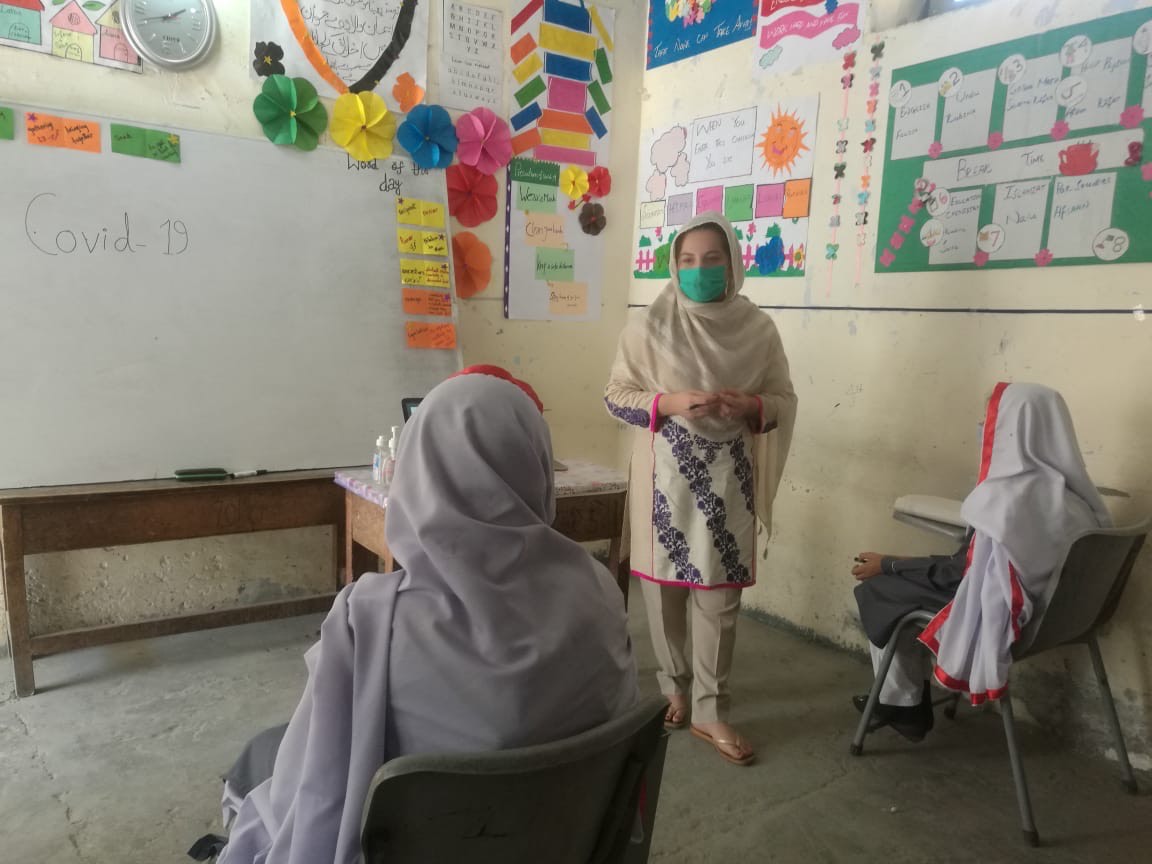 Graduate student speaking to an audience in a Pakistani classroom