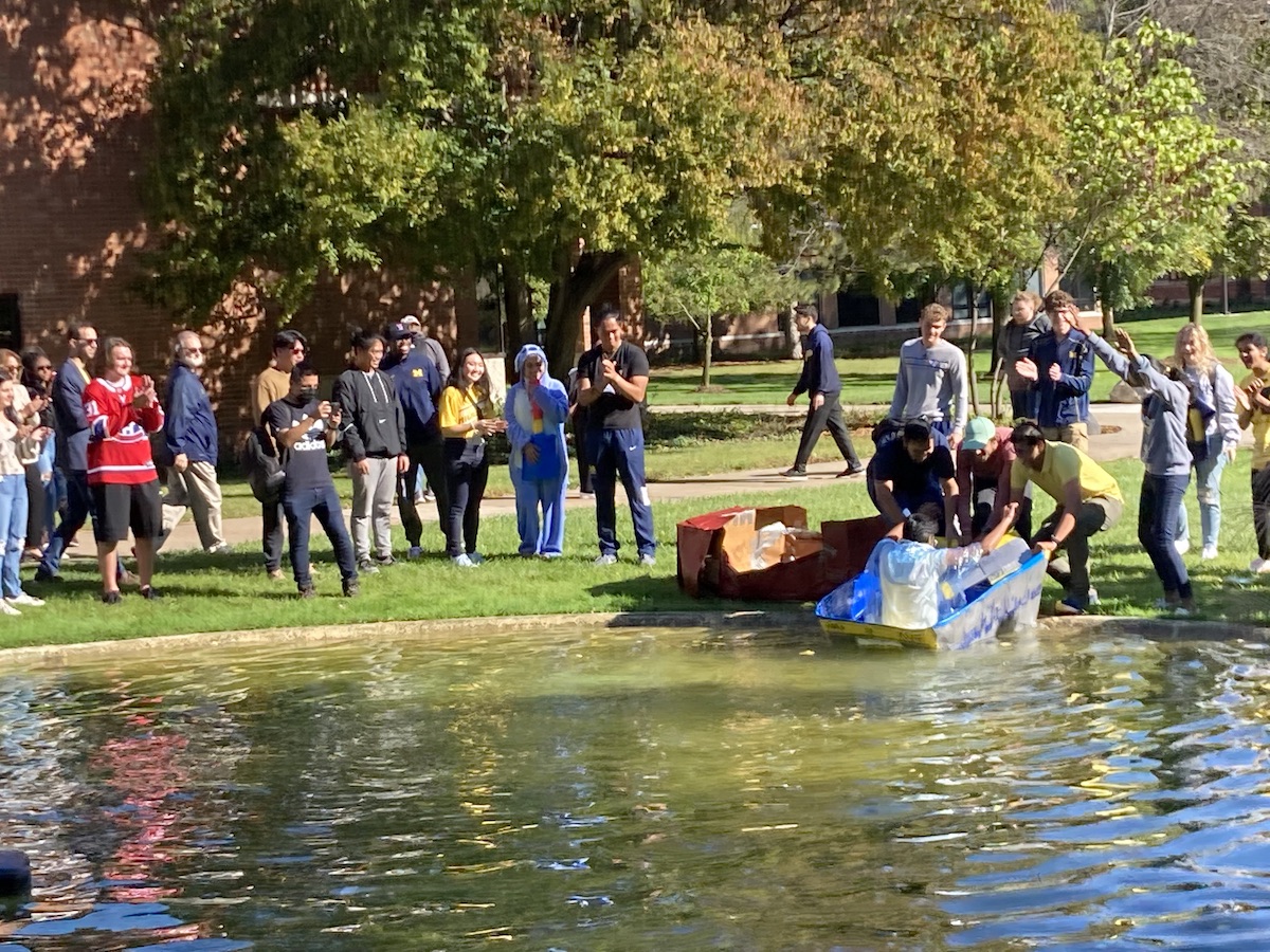 Students racing boats in the pond.