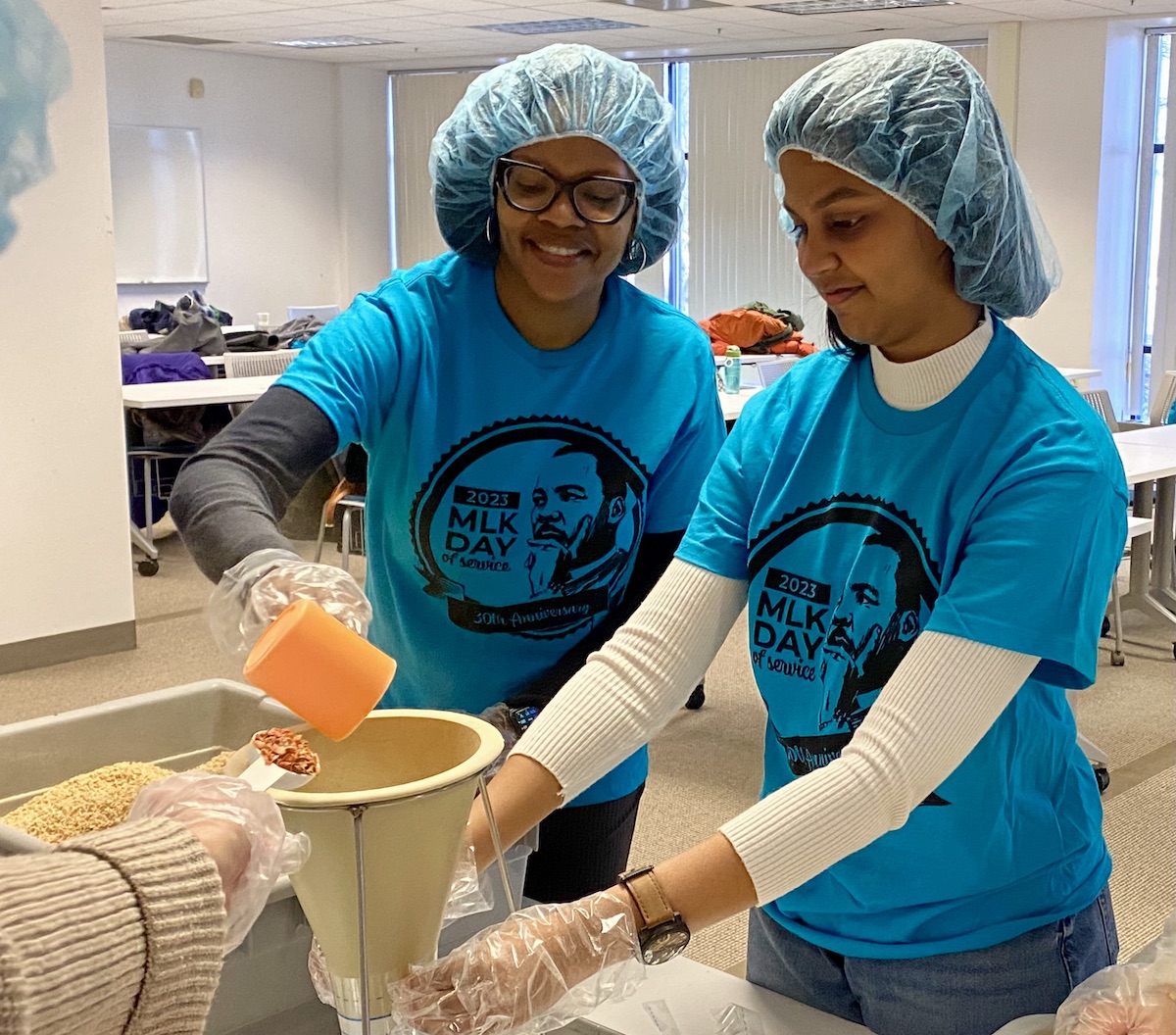 UM-Dearborn Chief Officer for Inclusion and Diversity Keisha Blevins and graduate student Alvita Yathati package the nutrient mix, which will be sent to hungry families.