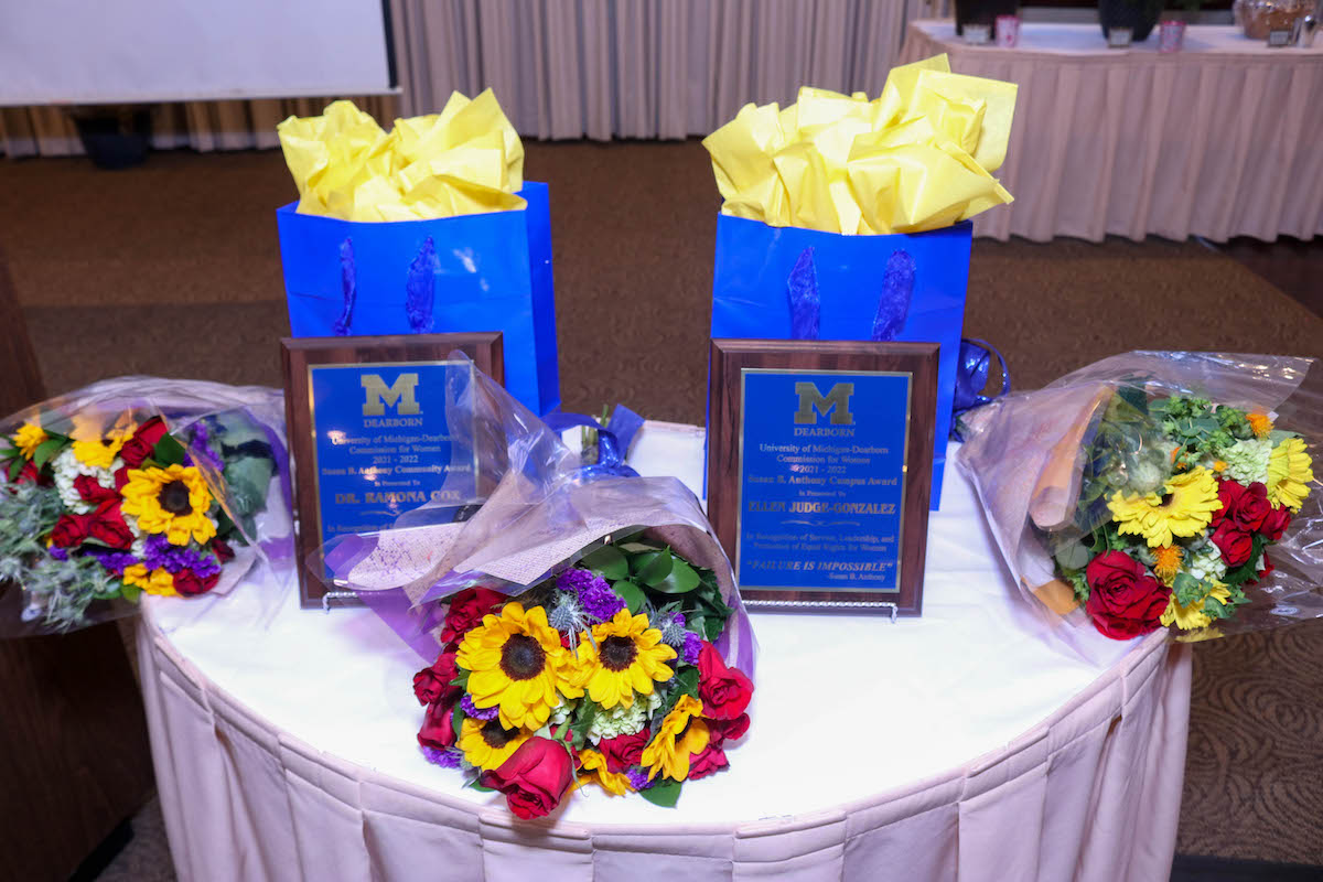 Susan B. Anthony Campus and Community Awards and flowers on table.