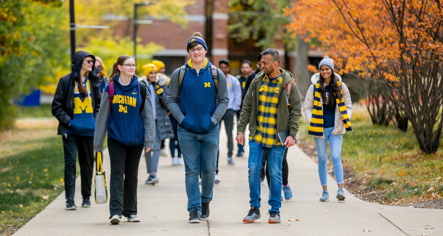 Students dressed in UM gear walking across campus