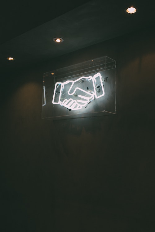 Neon lights in the form of a hand shake.