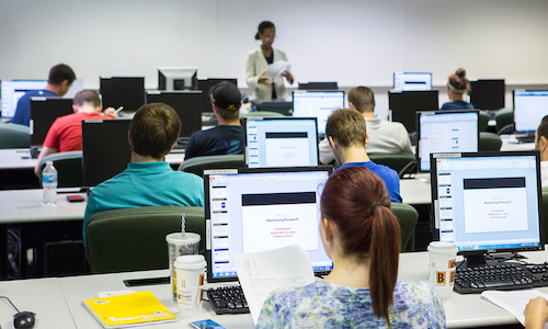 Students in computer lab with instructor in the front of the room.