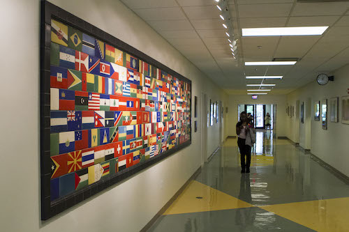 Hallway with flags of nations from around the world displayed.