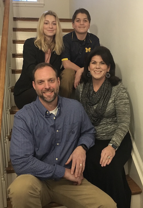 Student Mark Wonsul poses for a family portrait with his wife and two teenage children, sitting on the stairs of their home. 
