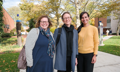  UM-Dearborn faculty Lisa Martin, Emily Luxon and Mercedes Miranda standing outside the Administration Building on a fall day. 
