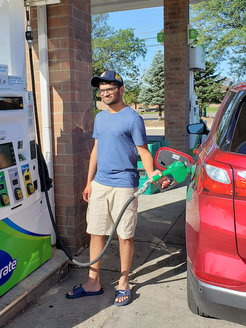  UM-Dearborn student Shouryan Nikam pumping gas at a gas station. 
