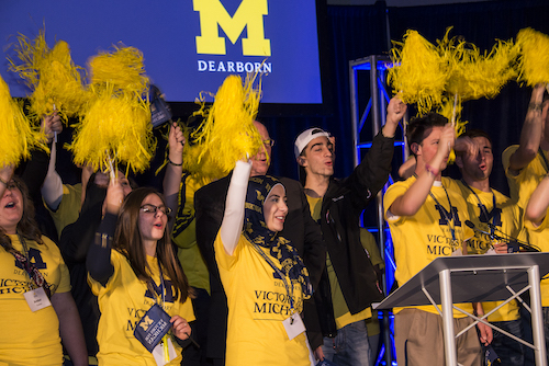 Students with pom-poms cheering for Michigan