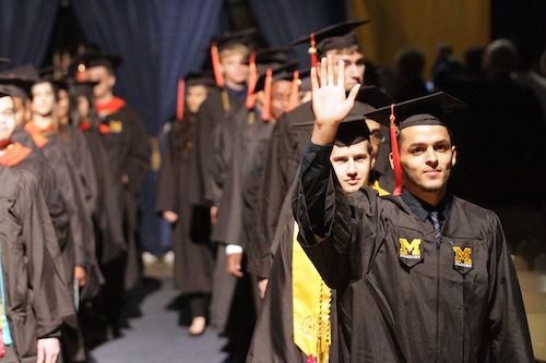 Graduates in line with first student waving.