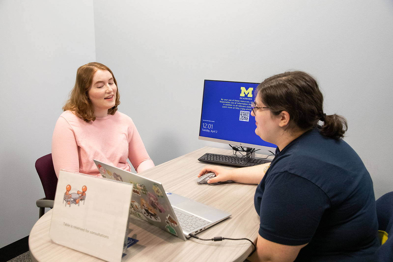 Two students discussing over a computer