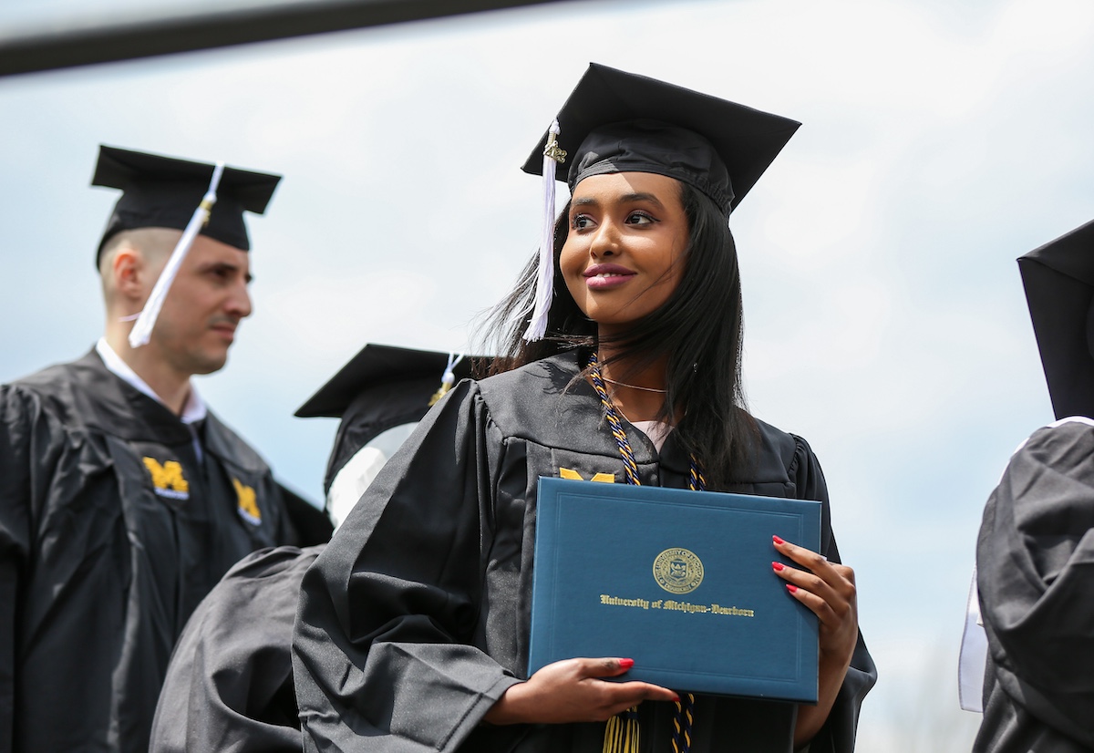 African-American female student smiling holding her dipolma