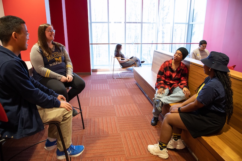 several students sit in a common area talking