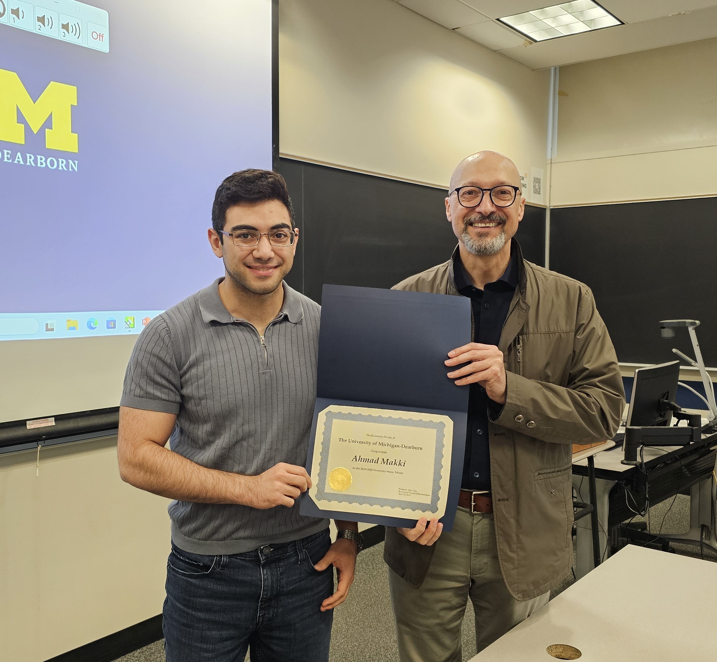Professor of Economics, Ilir Miteza presenting award to student, Ahmad Makki 