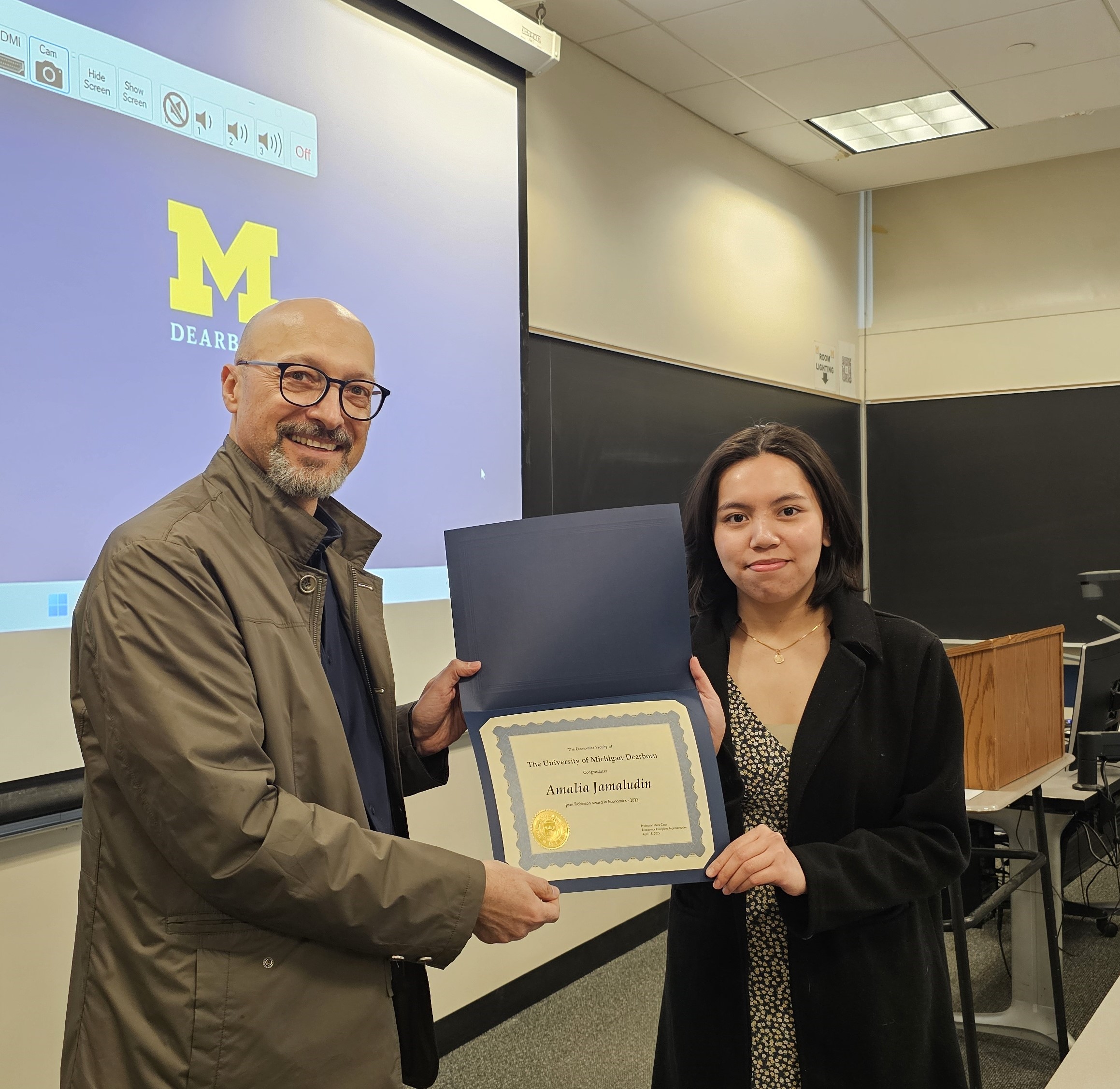 Professor of Economics, Ilir Miteza presenting award to student, Amalia Jamaludin