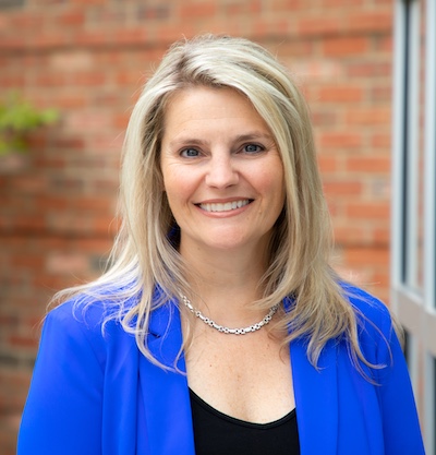 A photo of a blonde-haired woman in a blue jacket
