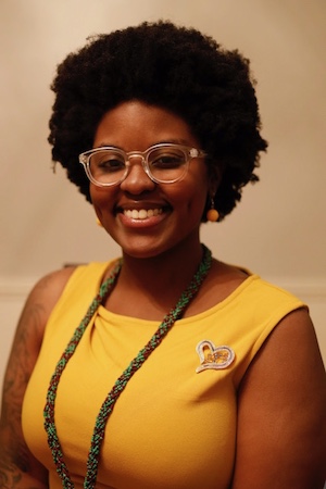 A woman wearing bright yellow poses for a portrait 