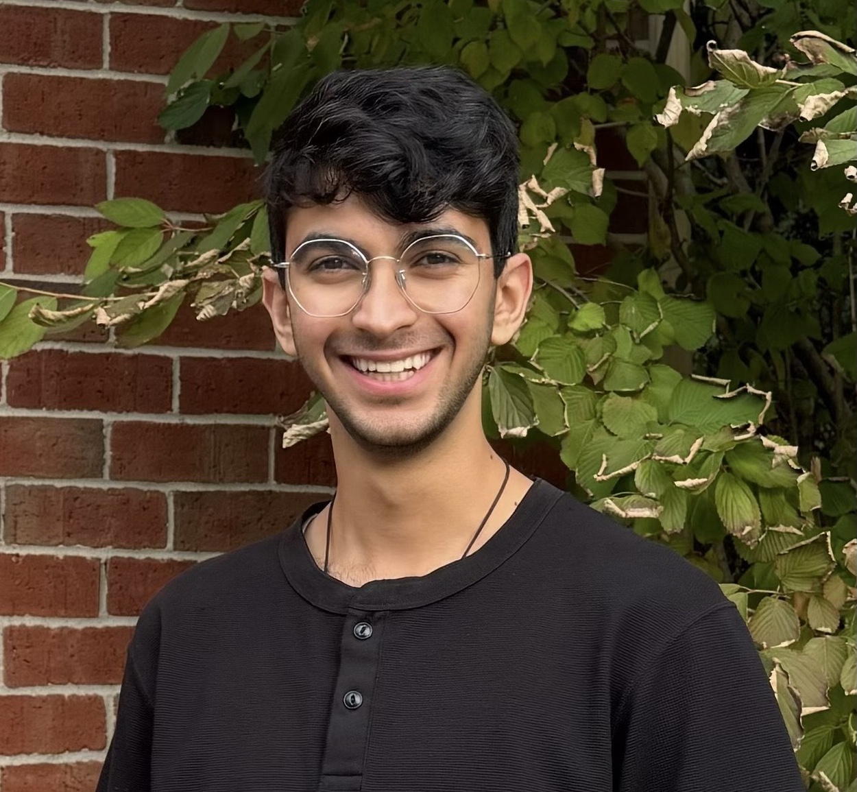 A photo of a smiling male in a black shirt