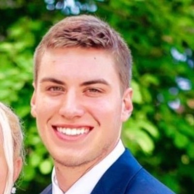 A smiling man is wearing a blue suit