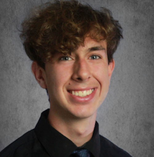 Portrait of a young smiling man wearing a navy blue dress shirt and a tie