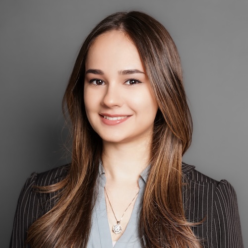 Portrait of a young woman in a gray blouse and a black suit jacket