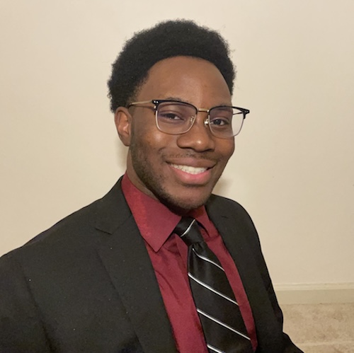 Professional portrait of a young man wearing a maroon dress shirt, black jacket and tie