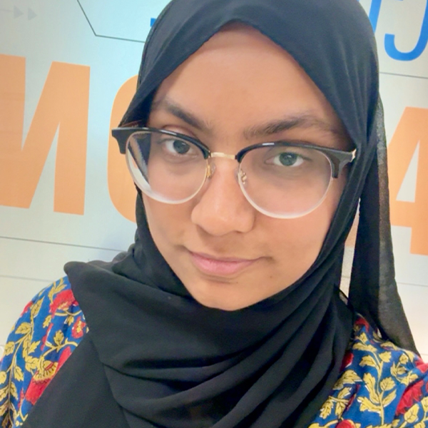 Selfie of a person with glasses and floral shirt smiling. 
