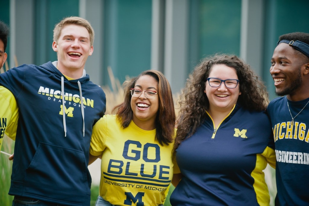 Smiling students dressed in UM-Dearborn gear