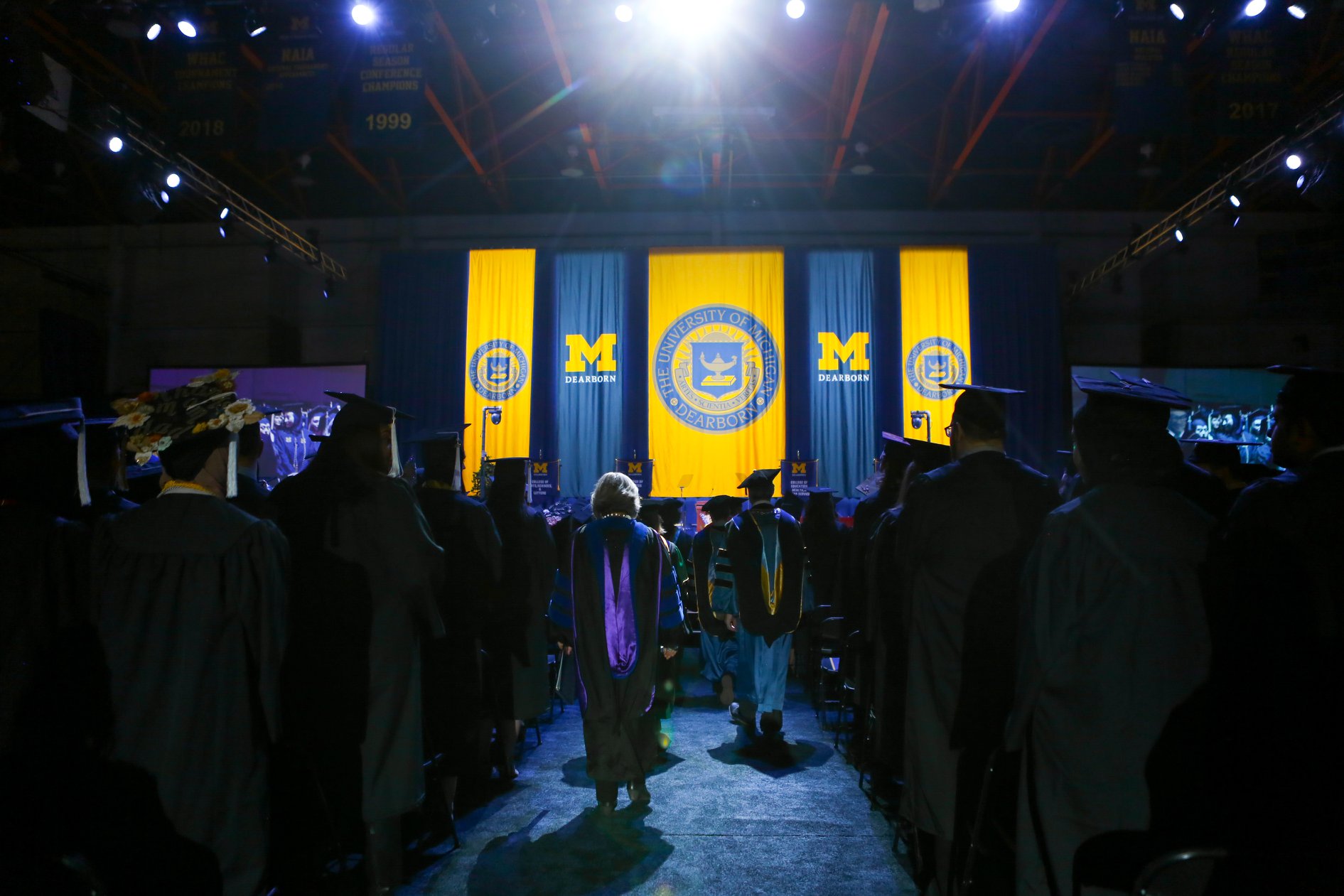 Wearing regalia, distinguished guests file down the main aisle of a commencement ceremony in 2019.