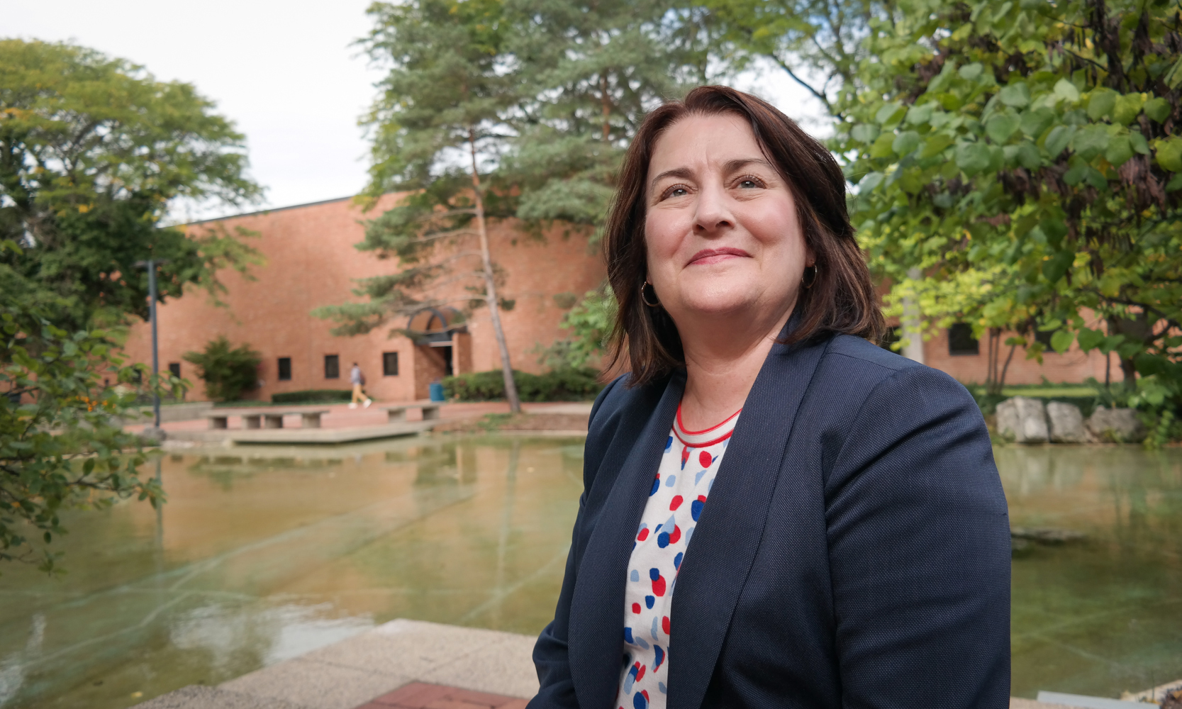 Becky Chadwick, executive director of institutional effectiveness and research standing in front of Chancellor's Pond
