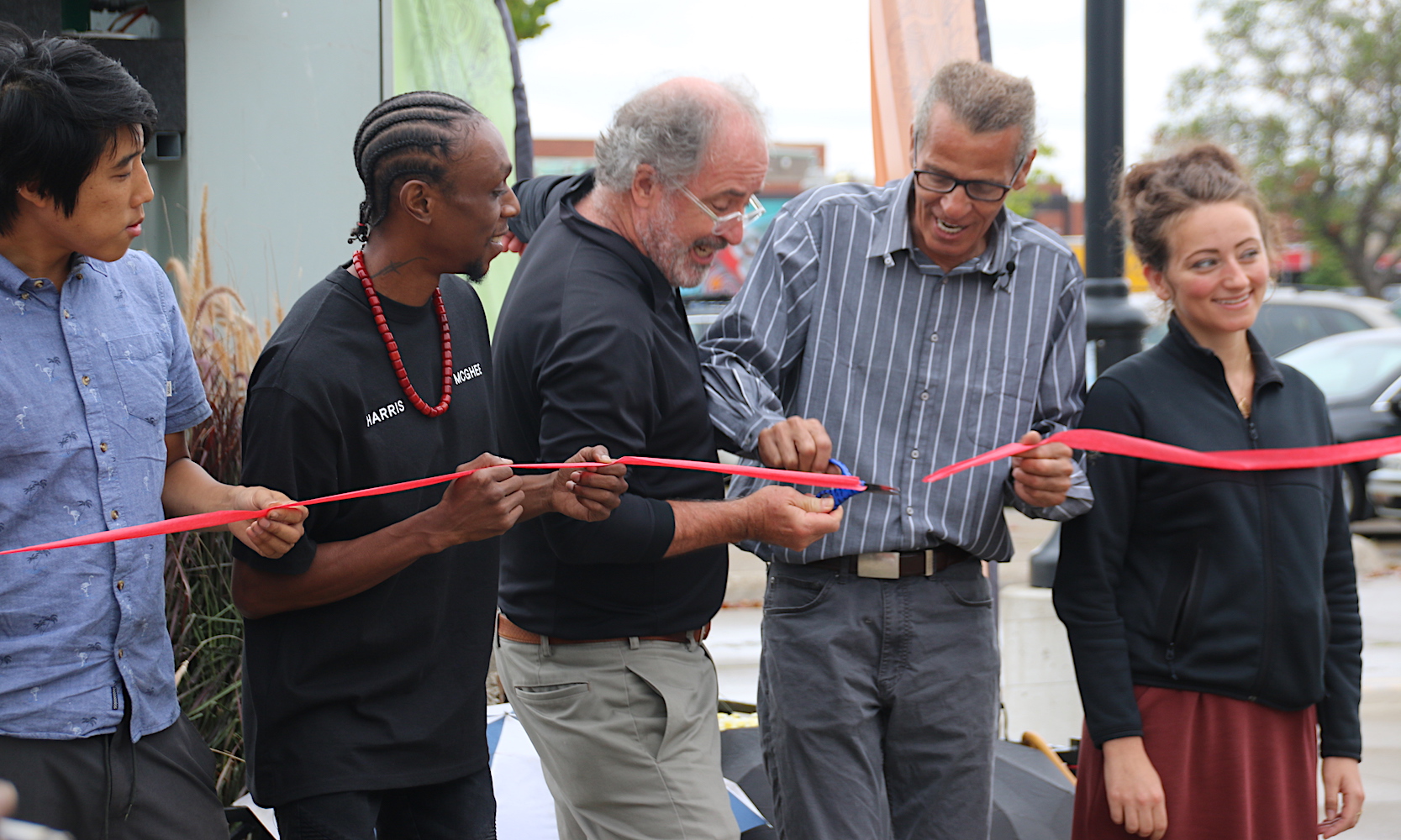 Carlos Nielbock, second from right, cuts the ribbon in front of his wind turbine at Eastern Market's Shed 5.