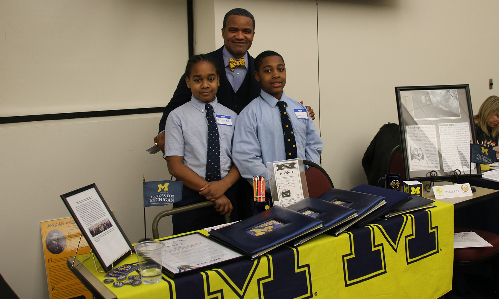 Rashid Faisal standing with two Frederick Douglass International Academy students