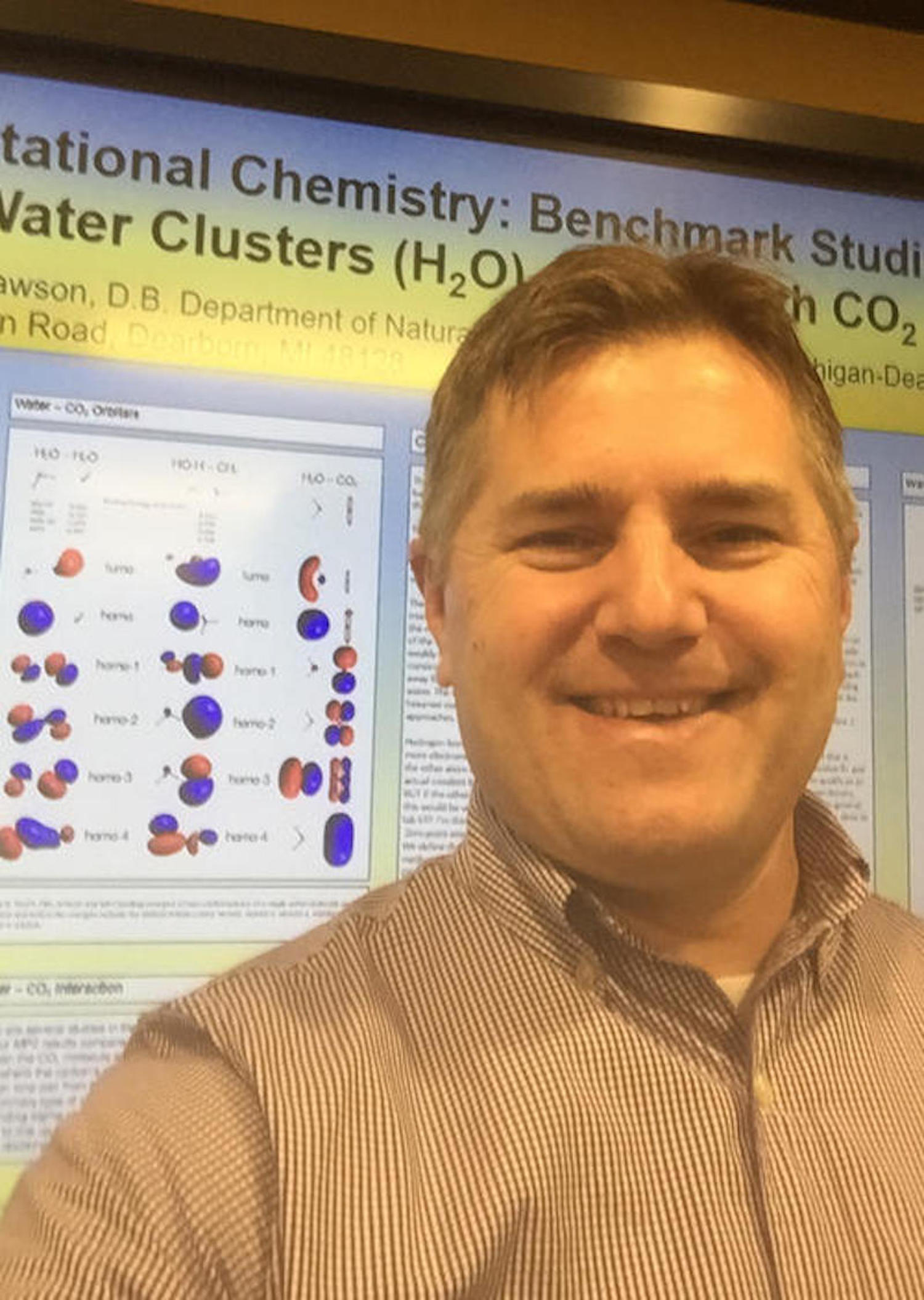 Professor Daniel Lawson standing in front of a research poster