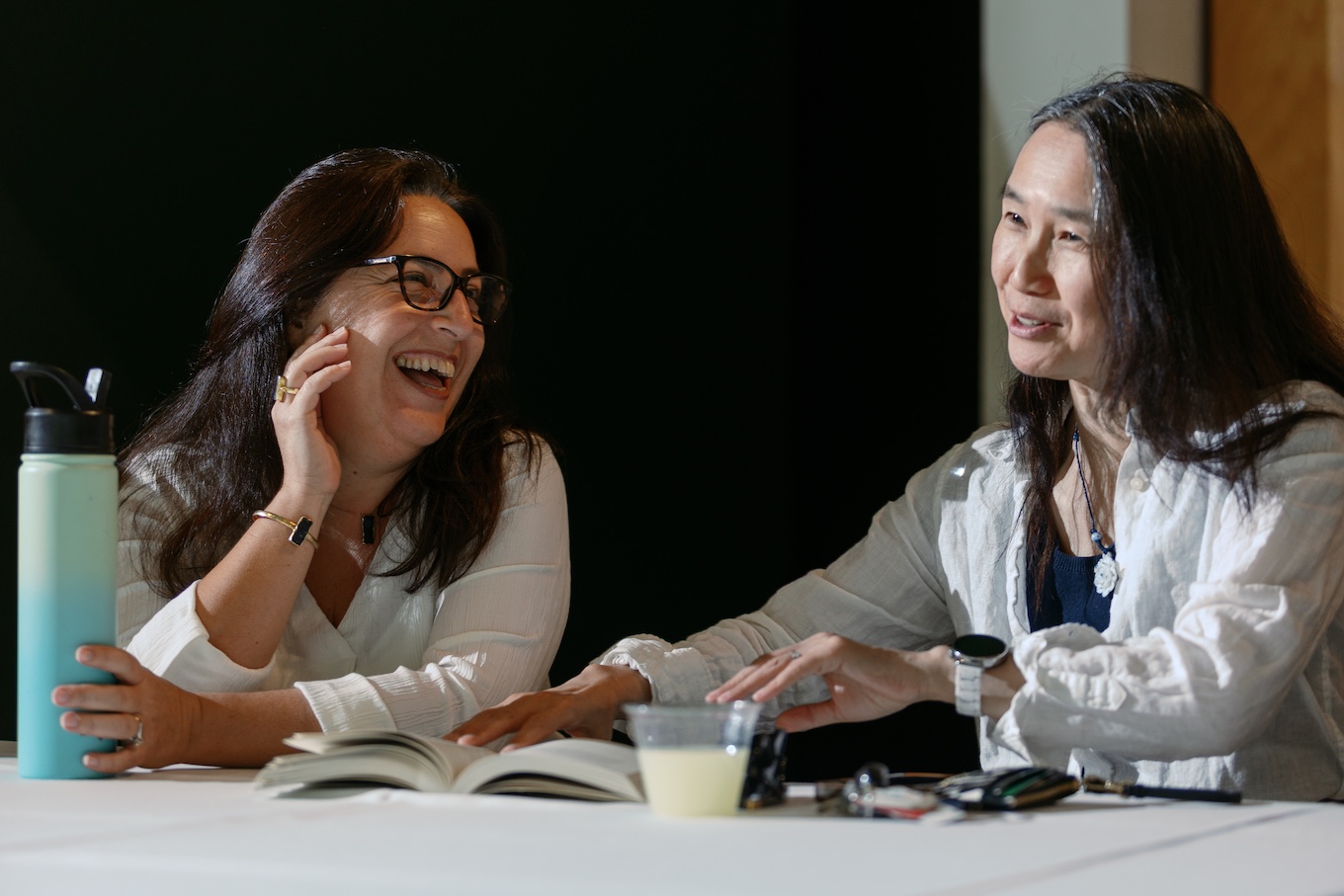Two women are talking while seated at a table