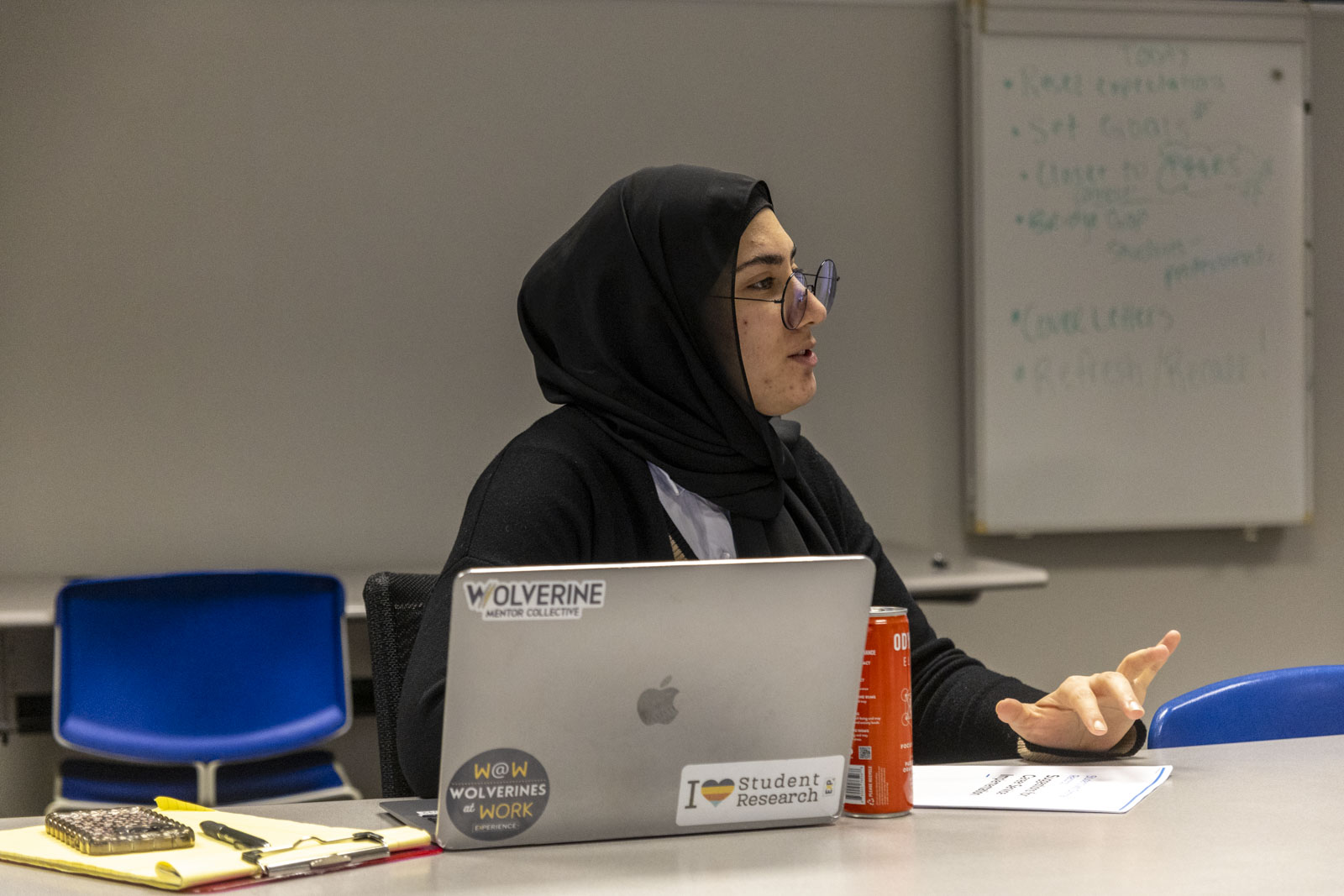 In a conference room, with a laptop in front of her, Career Coach Zainab Radi makes a point during a staff meeting.