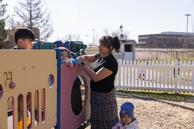 Student Teacher with children outdoors in playground.