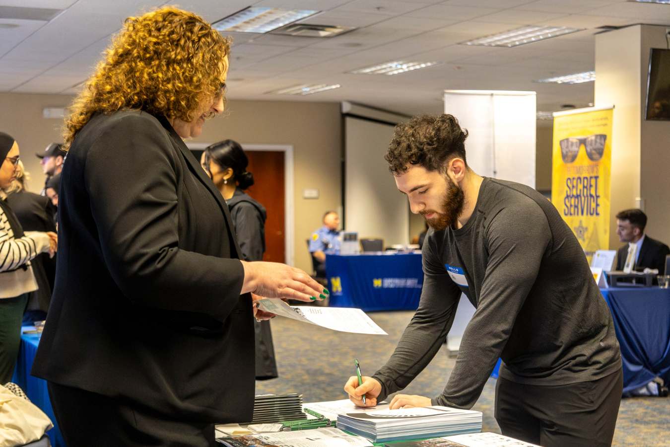 a student signs up at a table during a nonprofit government career fair