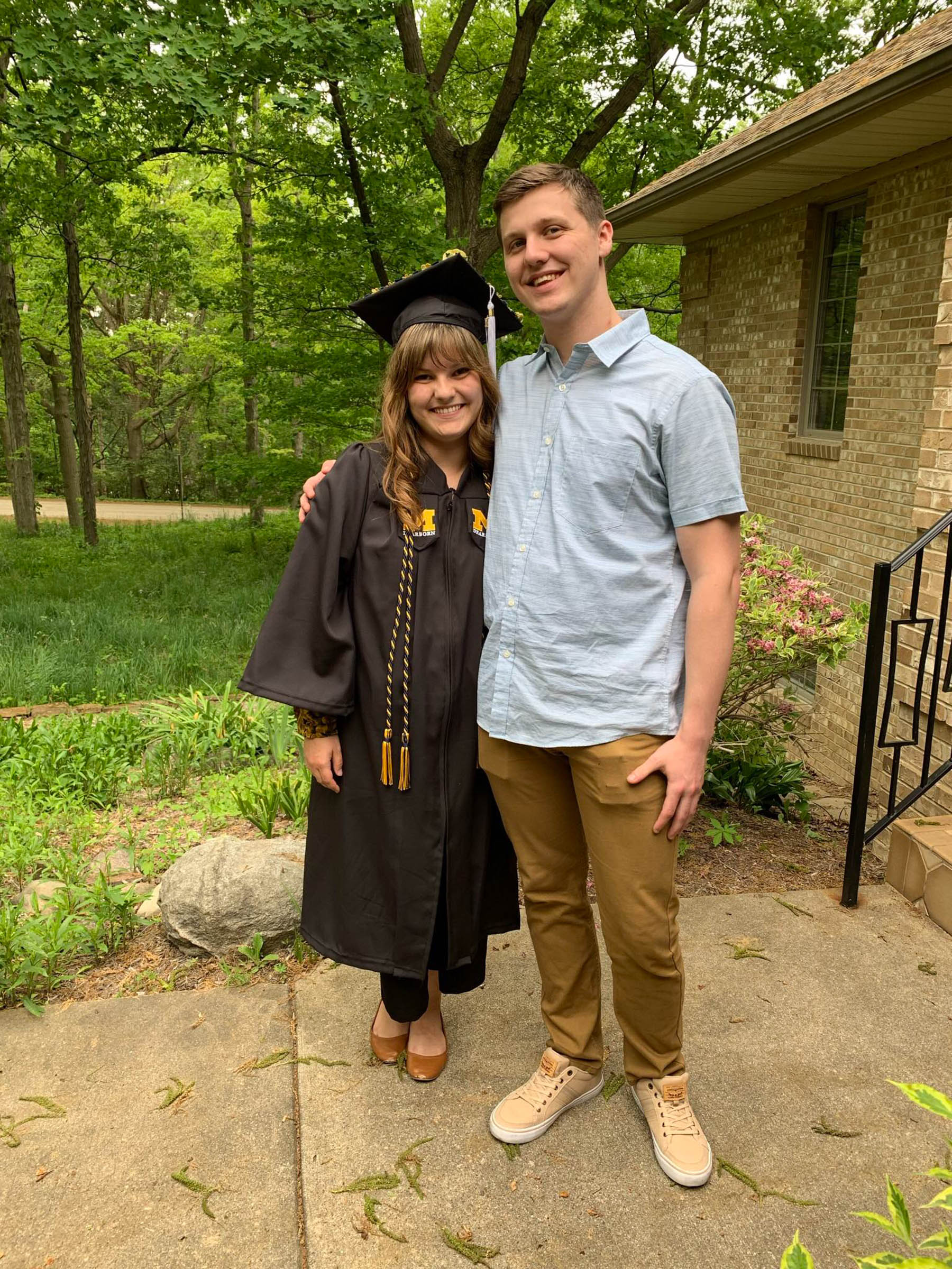 Gabrielle Weil and Alexander Cupps pose for a photo with Gabrielle wearing a cap and gown