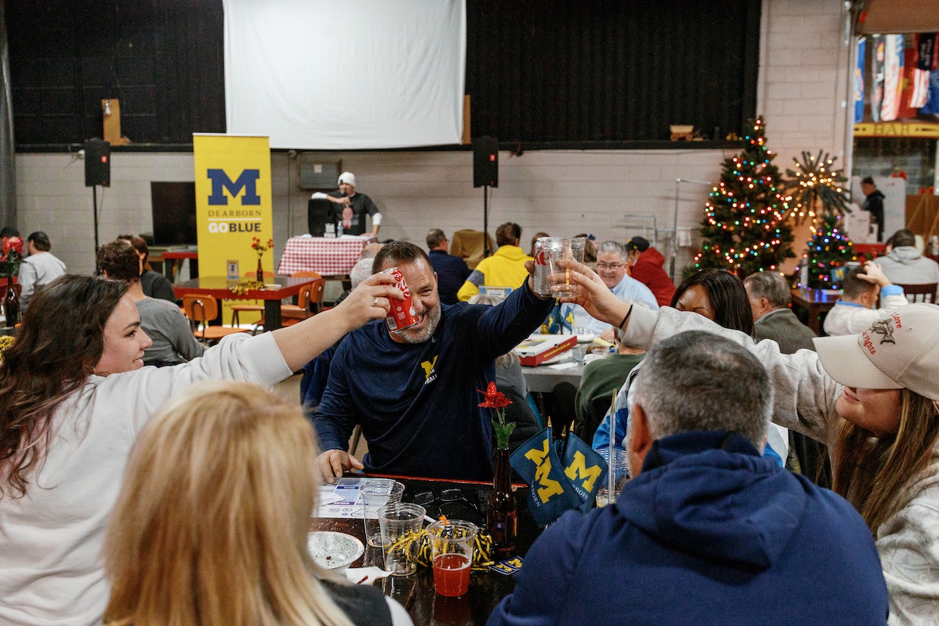 A group of people clank their glasses together in celebration
