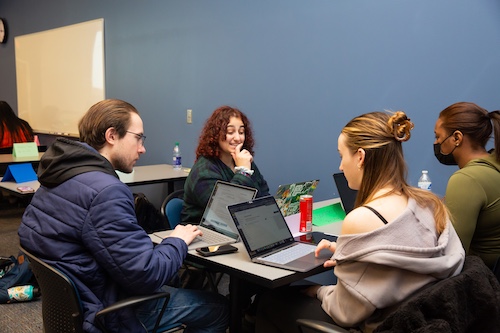 Group of students working on a project with their laptops.
