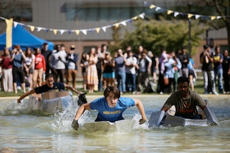 Students competing in cardboard boat race in Chancellor's Pond
